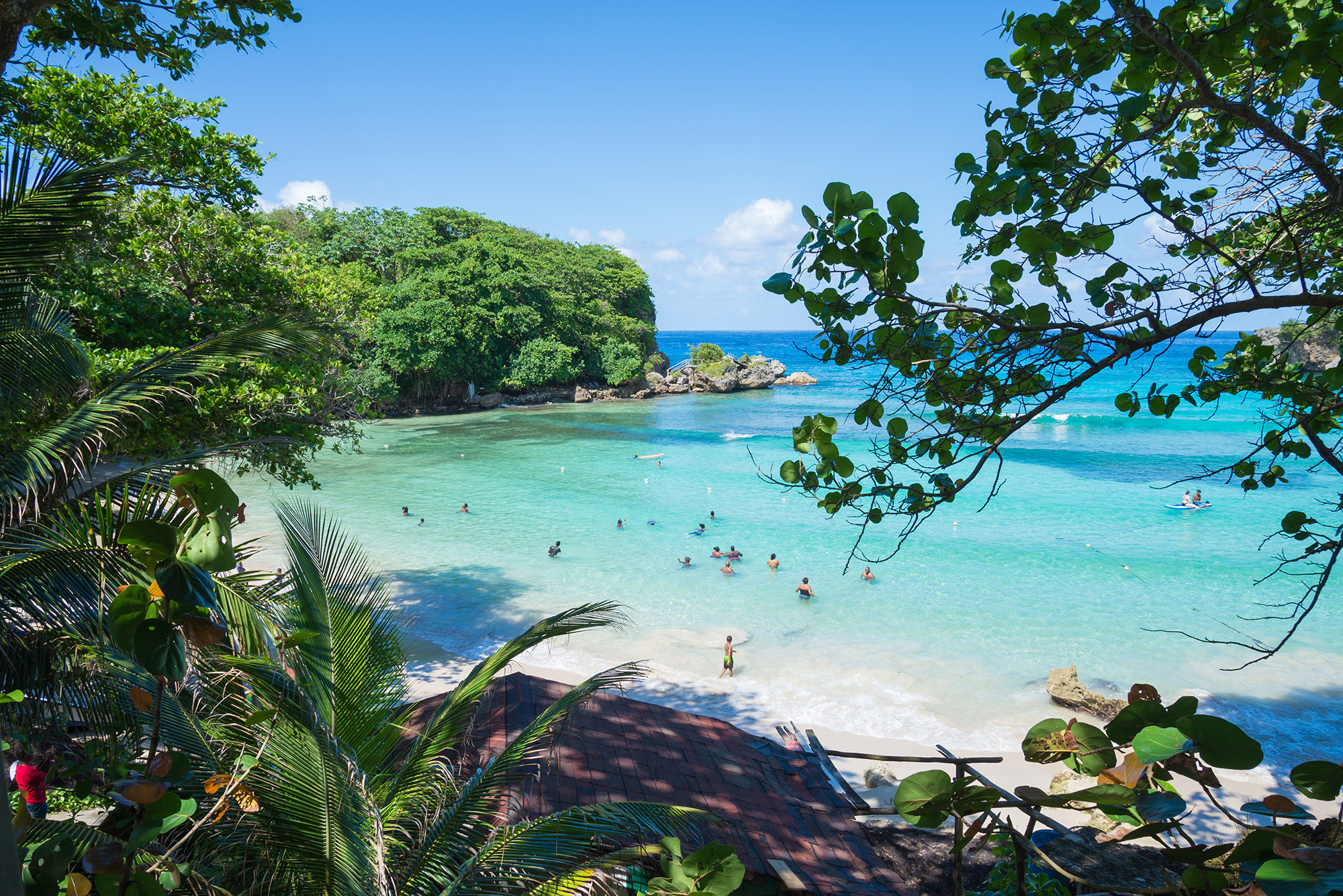 Group of people bathing in the turquoise waters at a tropical beach -