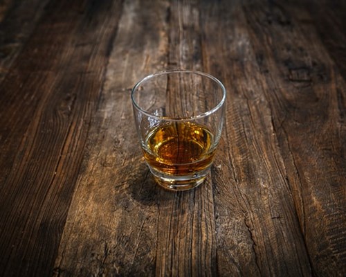 Small glass over rum on a wooden table