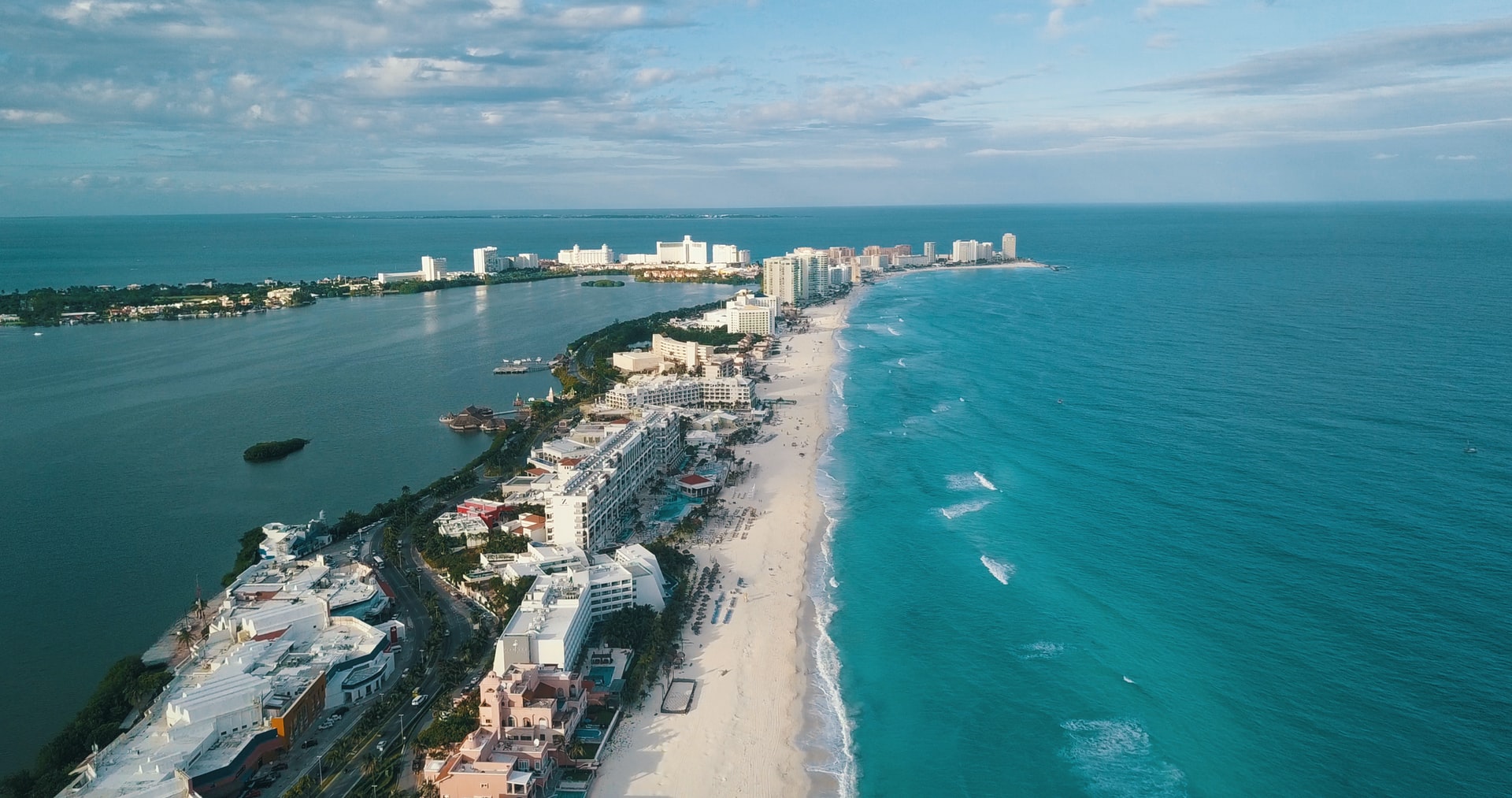 Aerial view of a long stretch of white sand beach lined with large hotels