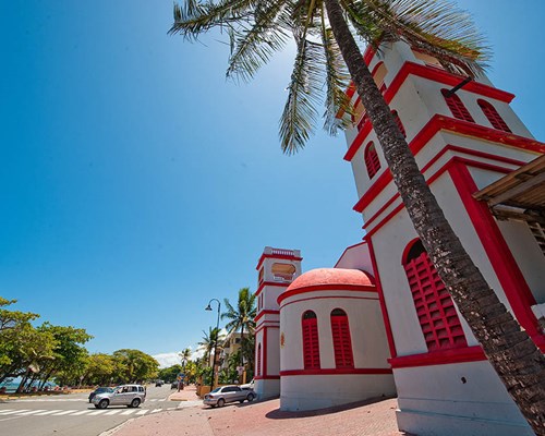 Red and white building opposite the beach in a tropical destination
