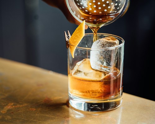 Rum poured into a glass on a wooden table