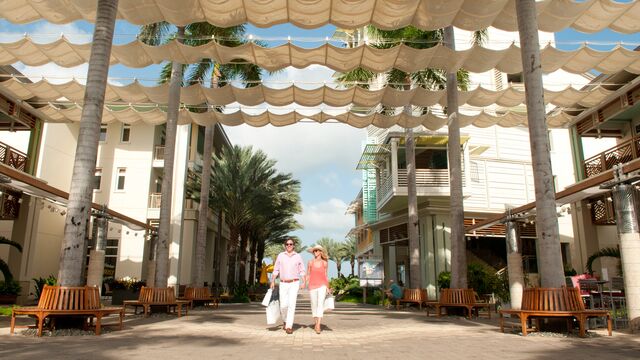 Man and women shopping and walking between Caribbean buildings - Camana, Cayman islands