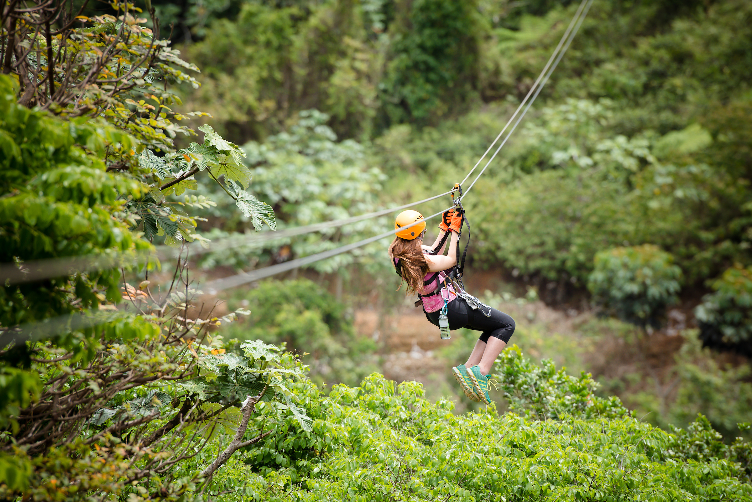 Exiting woman ziplining down enjoying a breathtaking view