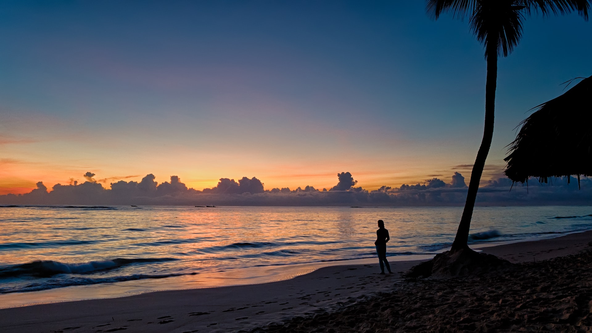 Person standing on a tropical beach watching the sunset in Punta Cana