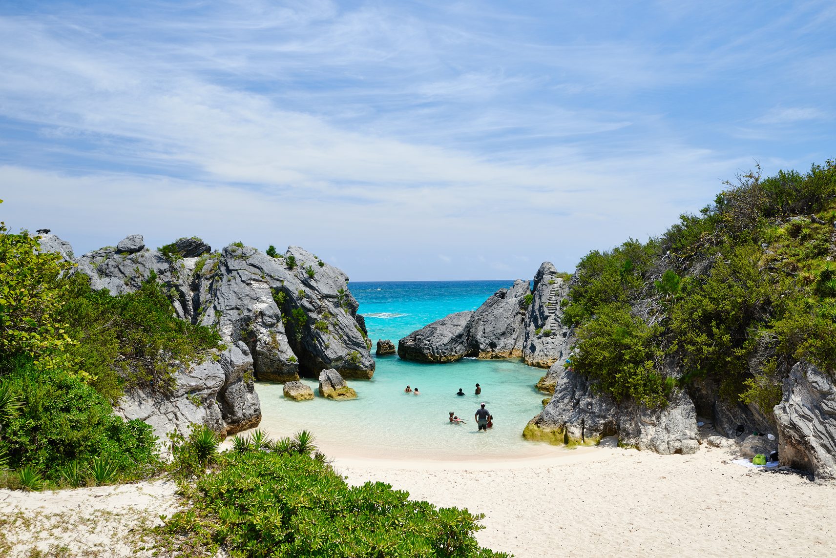 Rocky cove with people swimming in the blue lagoon 