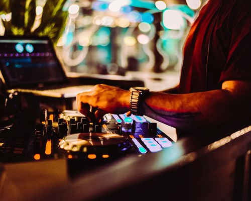 Man with red t-shirt playing with DJ controllers