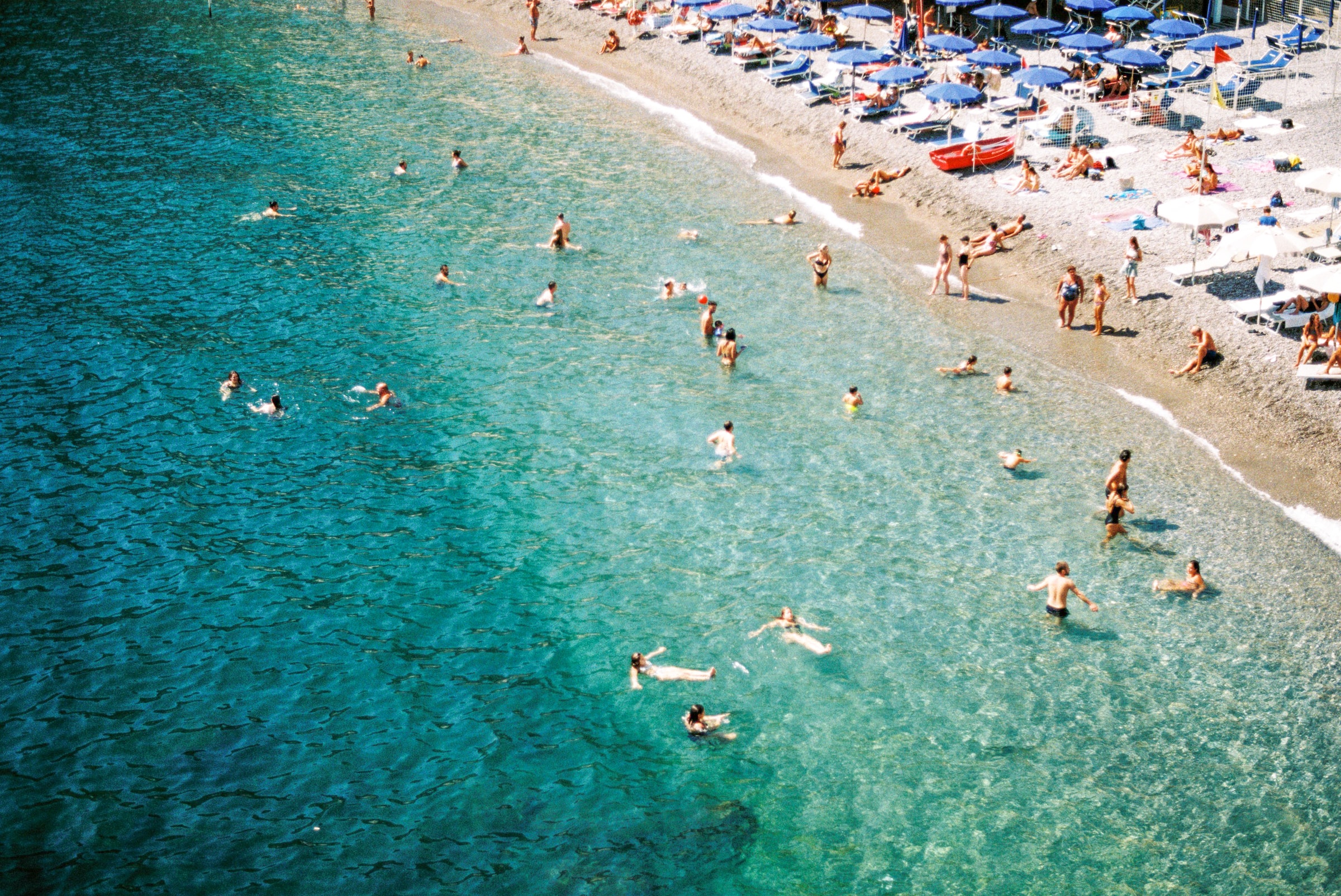 An azure beach packed with beachgoers