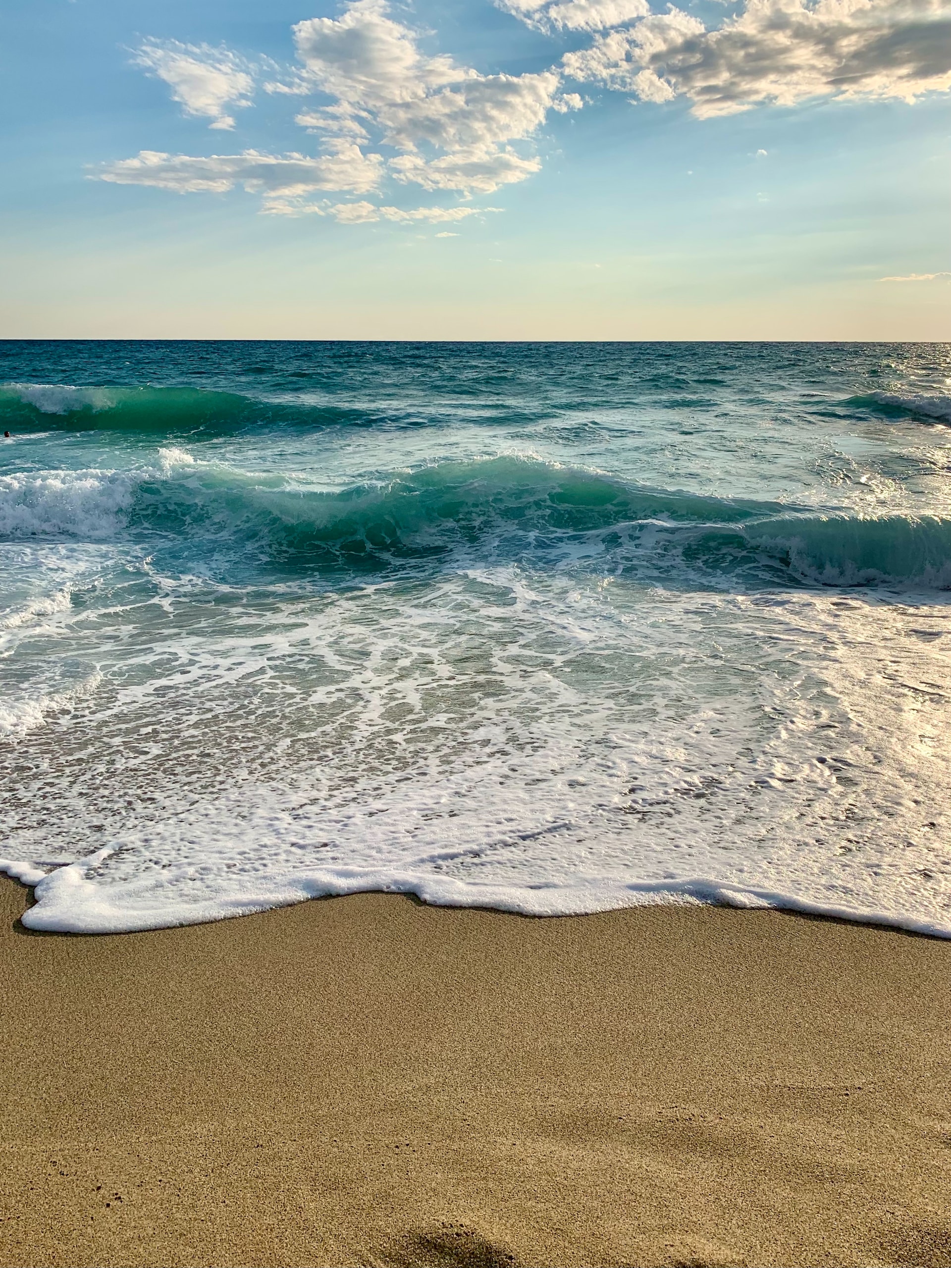 A beach with brown sands and azure waters