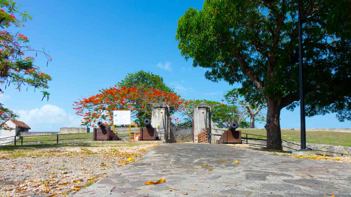 3 cannons at a stone doorway on top of a hil