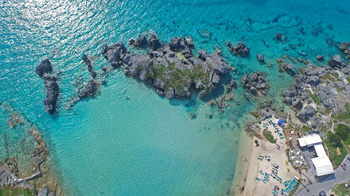 Aerial view of Tobacco bay, rocky sea and people settled on the beach