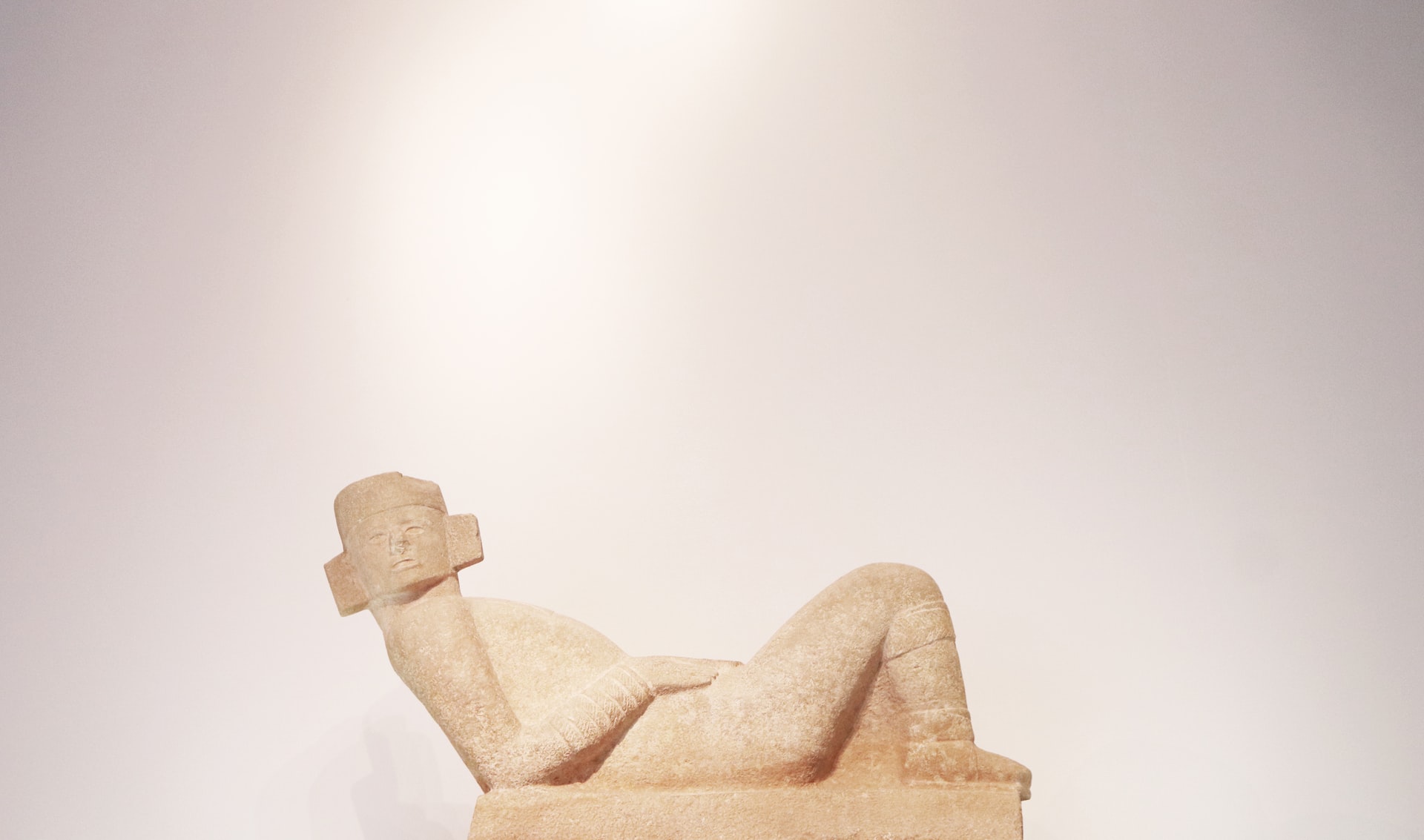 Beige coloured Mayan statue of person laying down