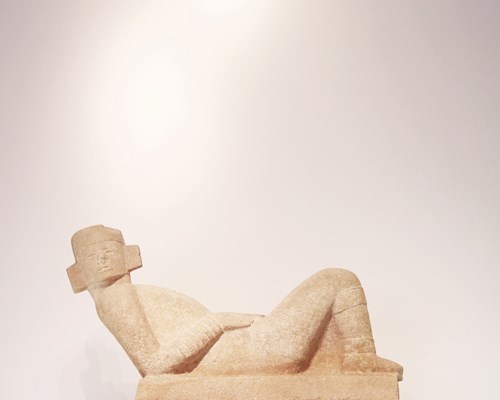 Beige coloured Mayan statue of person laying down