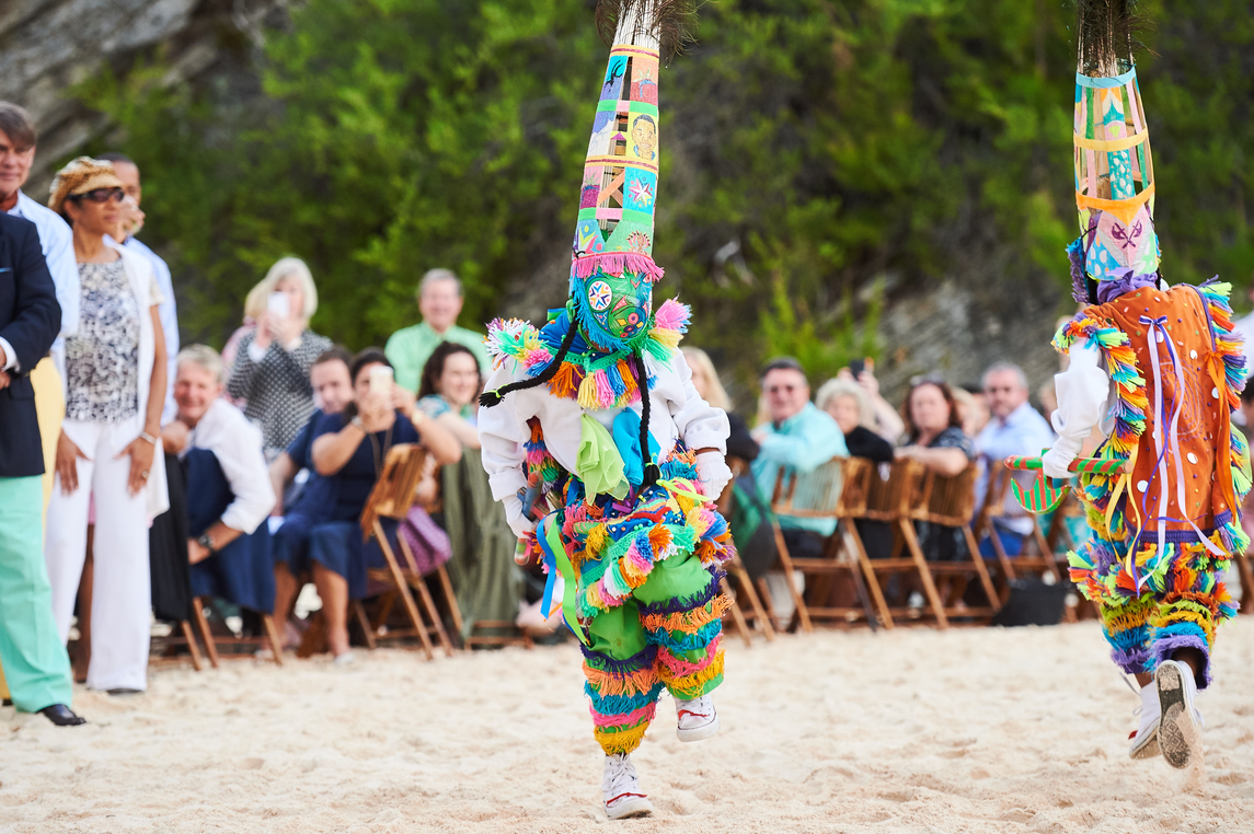 Person dancing wearing a colourful costume on the beach