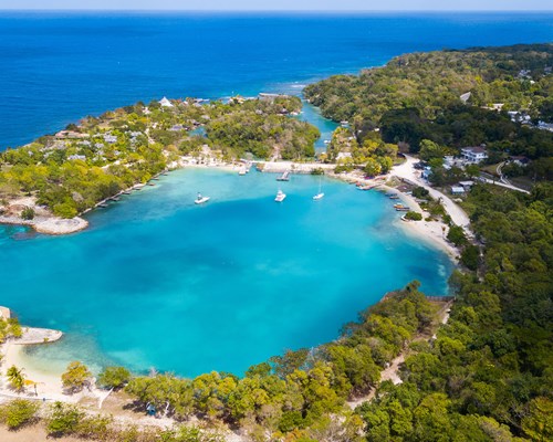 Aerial view of a cove with white sand beaches and bright blue water