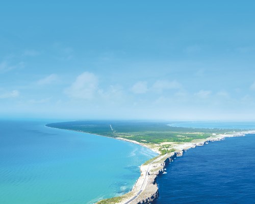 Narrow island with contrasting dark blue water on one side and turquoise water on the other