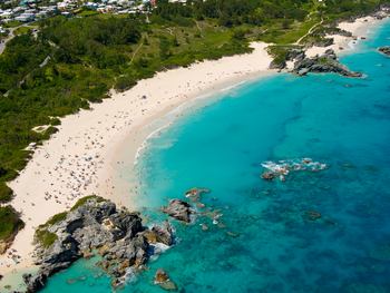 Aerial view of crescent bay merging with blue sea