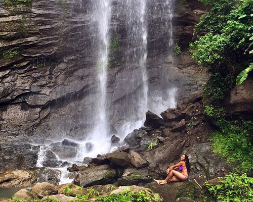 Woman sitting next to Royal Mt Carmel Waterfalls