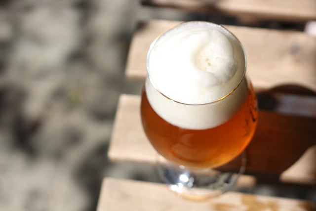 Close up of glass of beer on wooden table