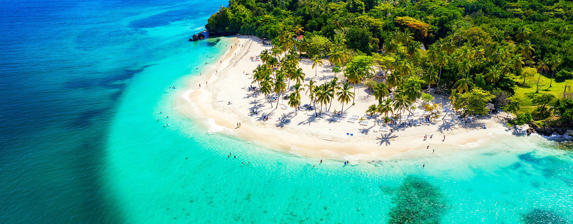 Aerial view of people enjoying a white-sand beach on a tropical island in the Maldives