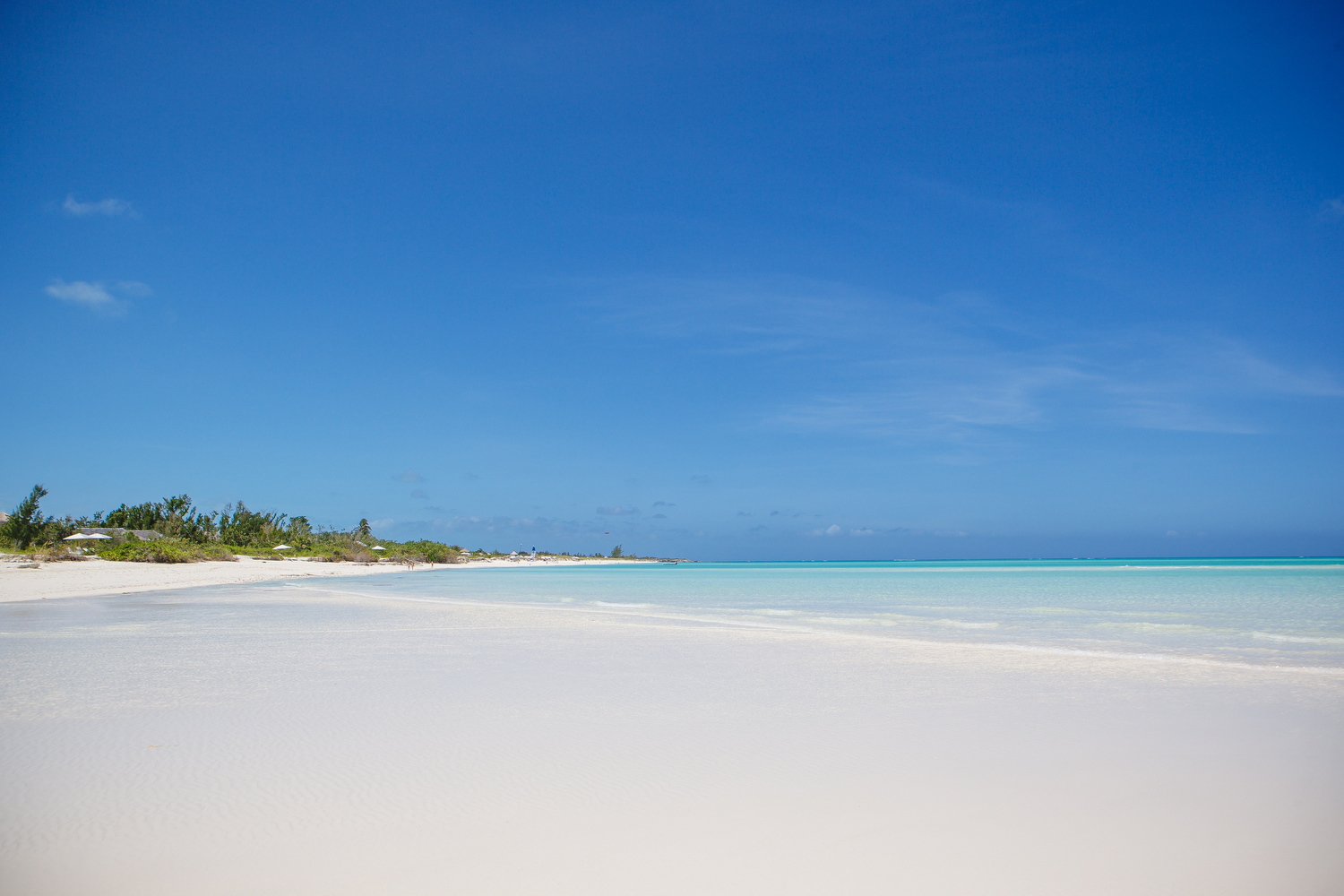 Wide white sand beach with calm bright blue sea 