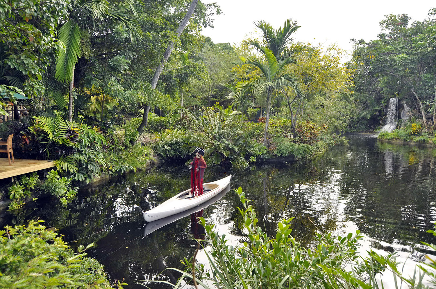 Pirate model standing in small boat surrounded by tropical plants