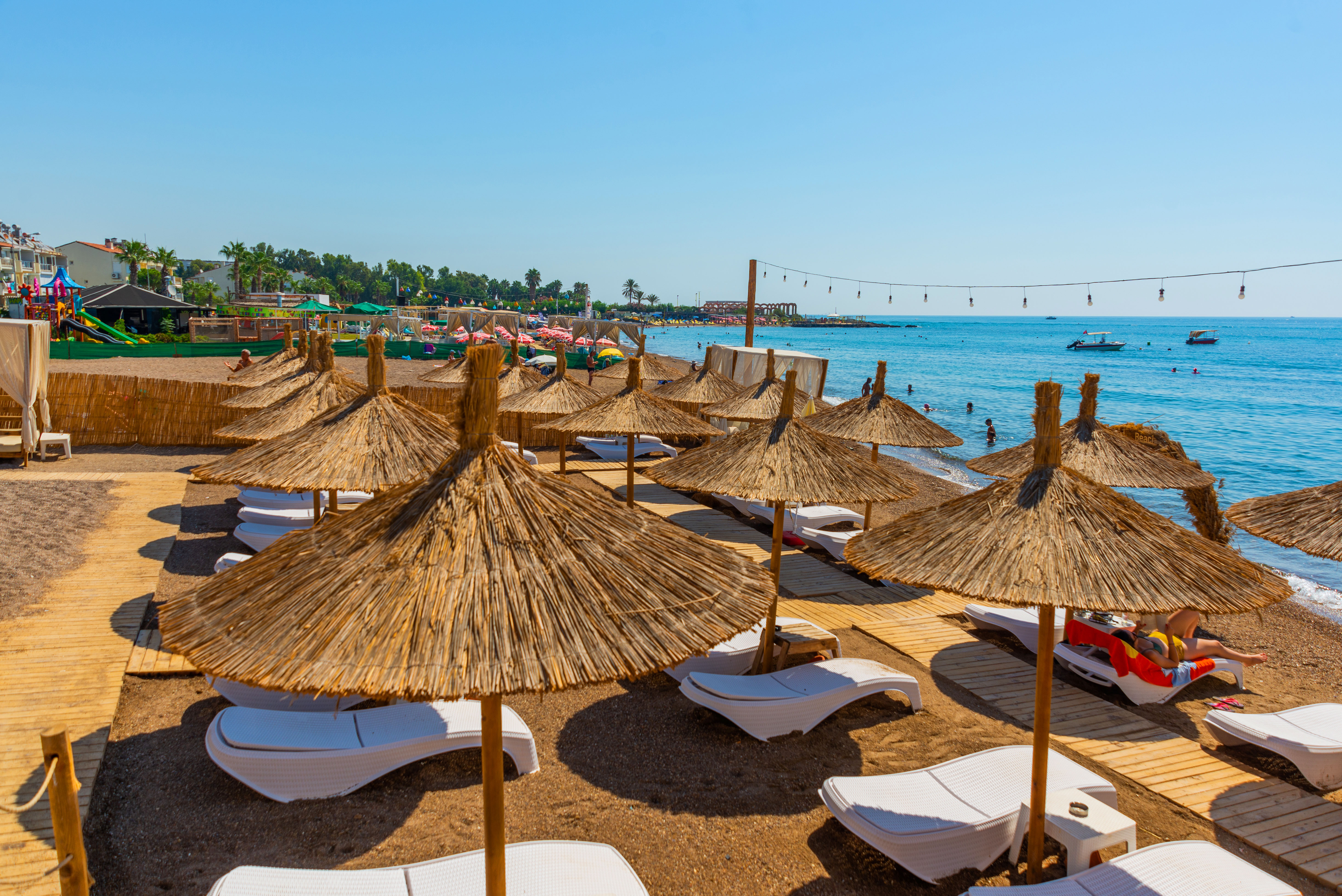 Lara beach straw parasols with blue sea behind near Icmeler in Dalaman