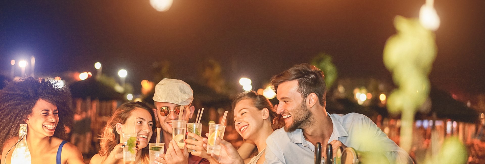 happy friends say cheers at the beach bar