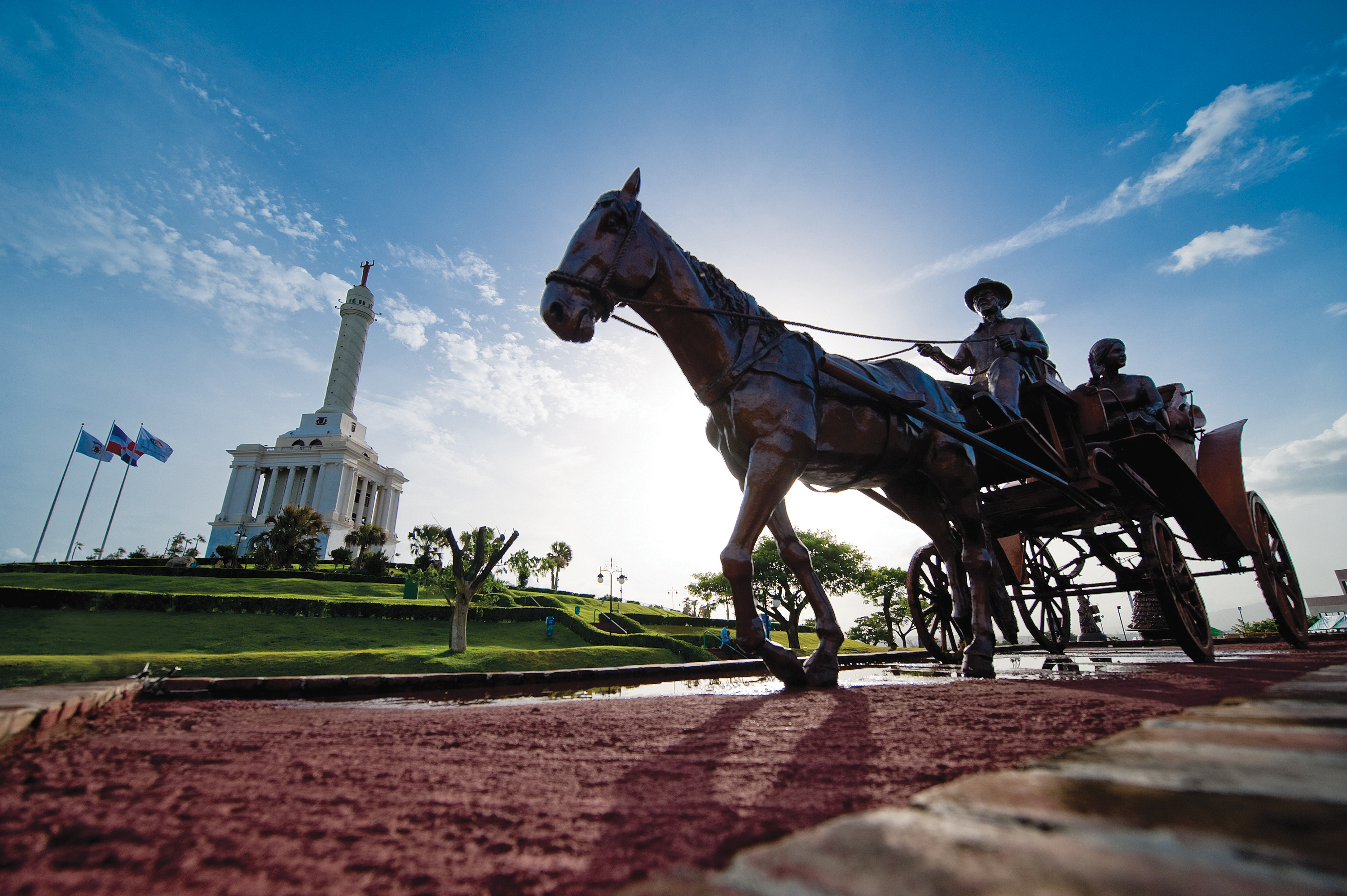 A statue of a horse drawn carriage next to an important white building 