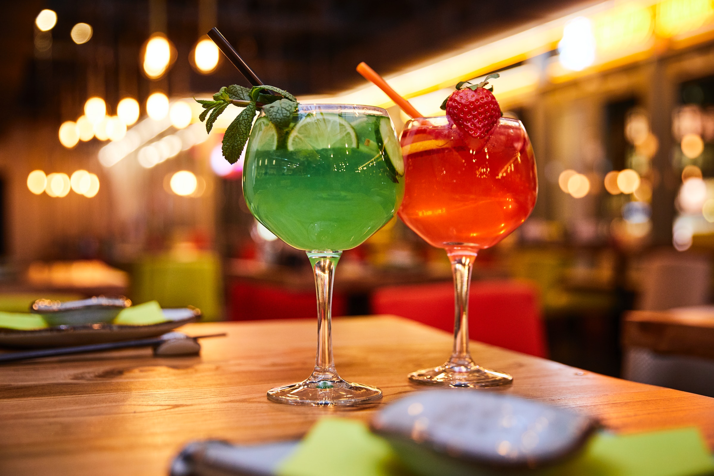 Green and red cocktails on a bar table