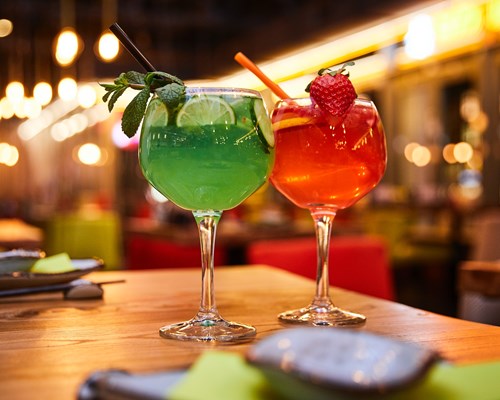 Green and red cocktails on a bar table