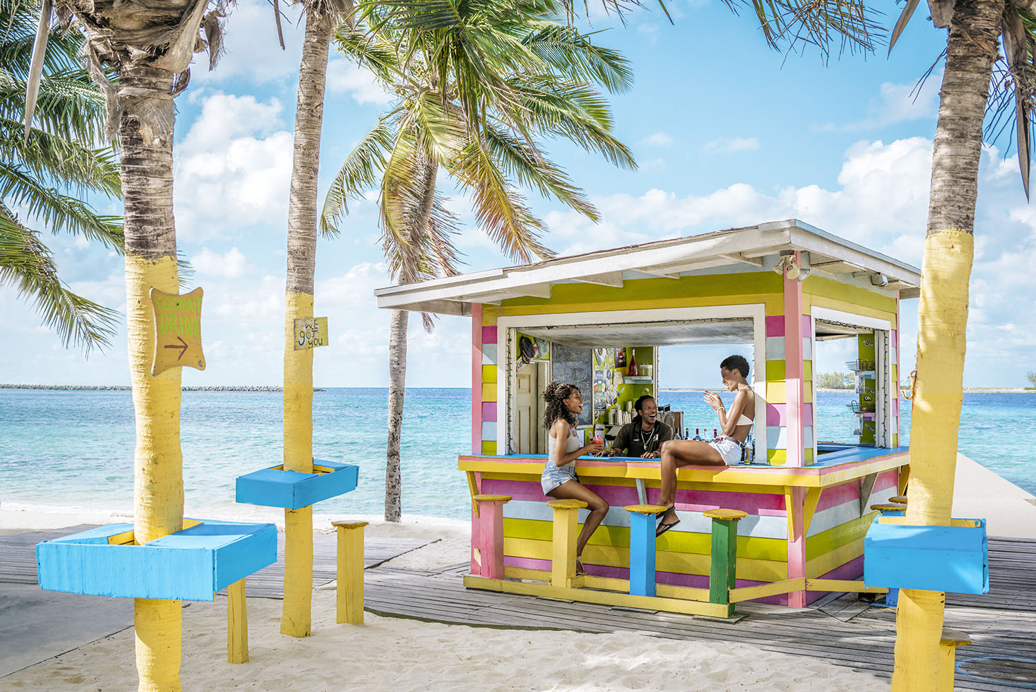 Friends sitting at a colourful beach bar in The Bahamas