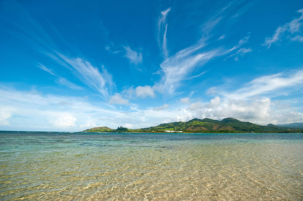 A view of a mountainous tropical island surrounded by turquoise sea