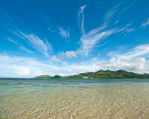 A view of a mountainous tropical island surrounded by turquoise sea