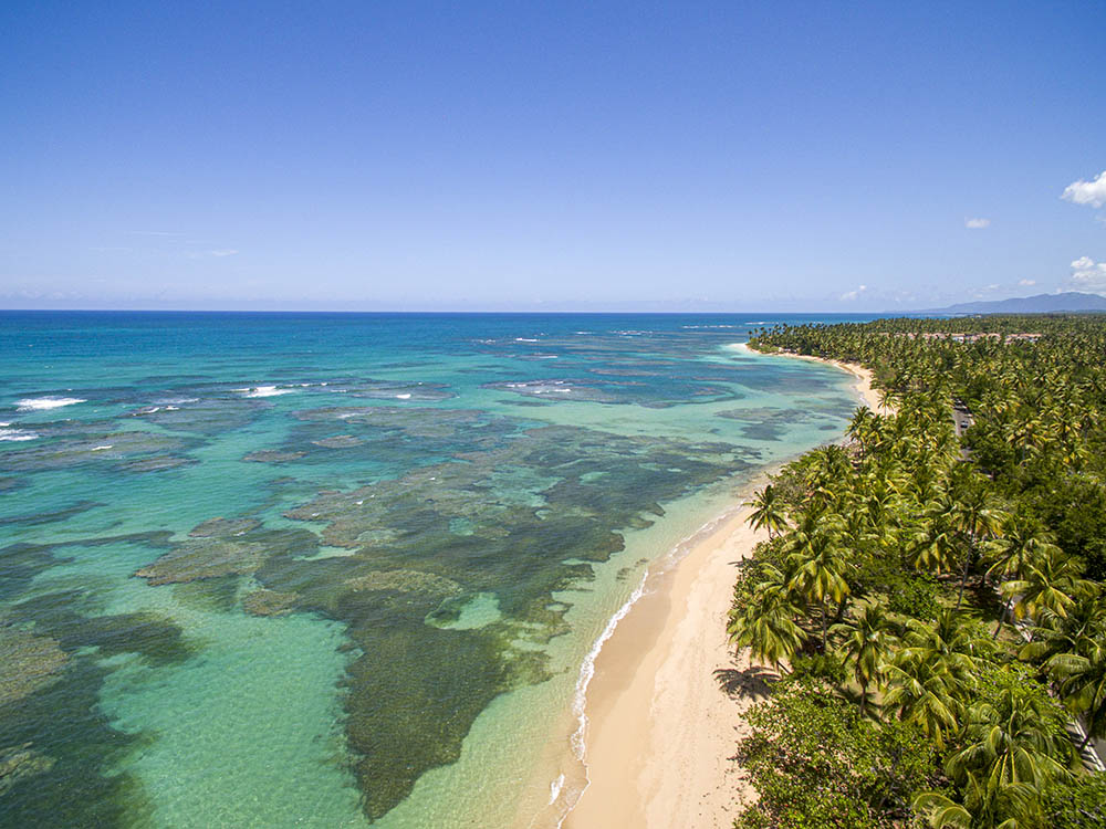 Aerial view of the shallow reefs next to a tropical beach