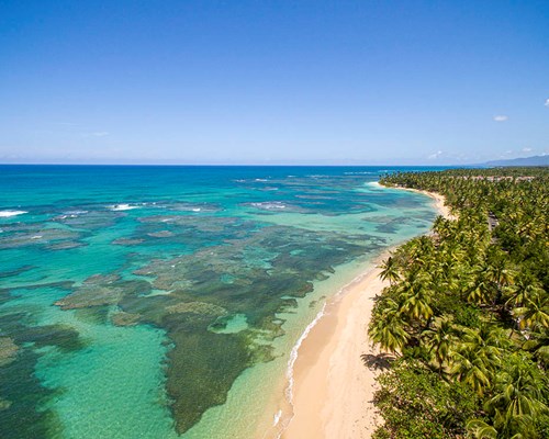 Aerial view of the shallow reefs next to a tropical beach