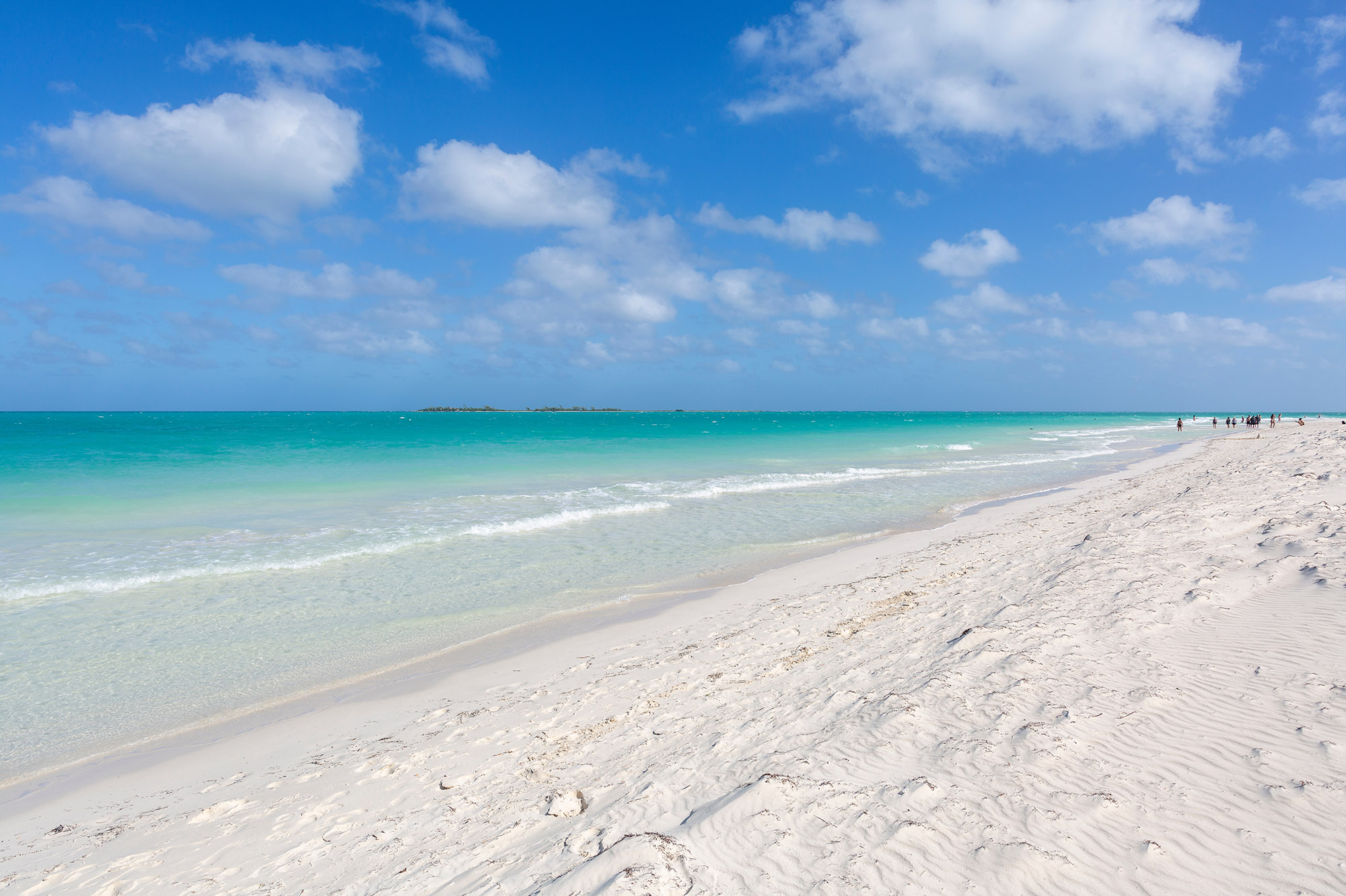 Picturesque long white sand beach lapped by clear blue calm water