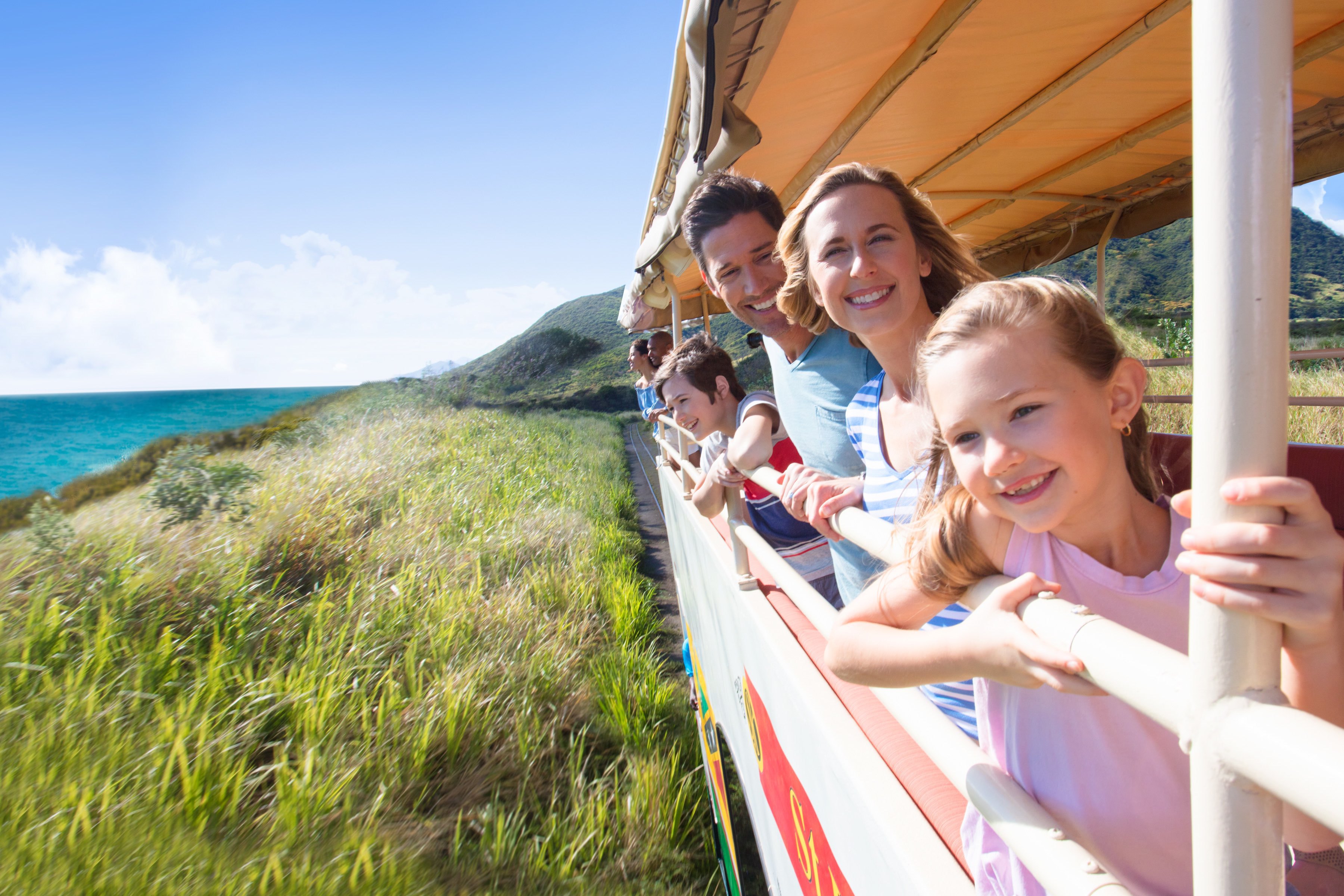 Family on board an open roof train travelling along coast 