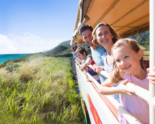 Family on board an open roof train travelling along coast