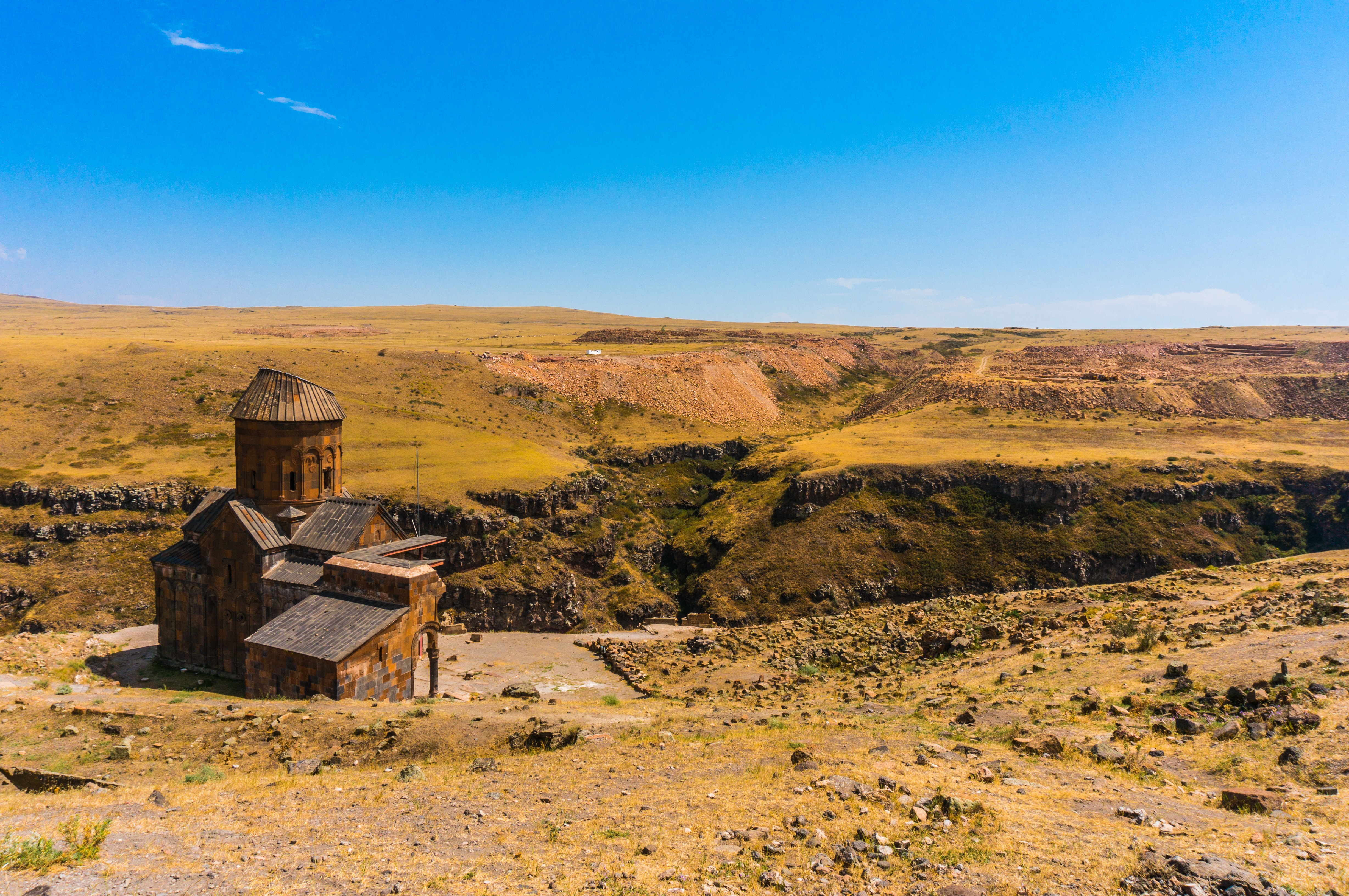 A landscape photo of a building among hilltops