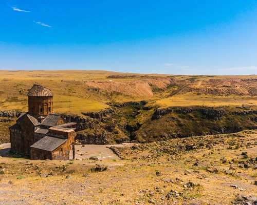 A landscape photo of a building among hilltops
