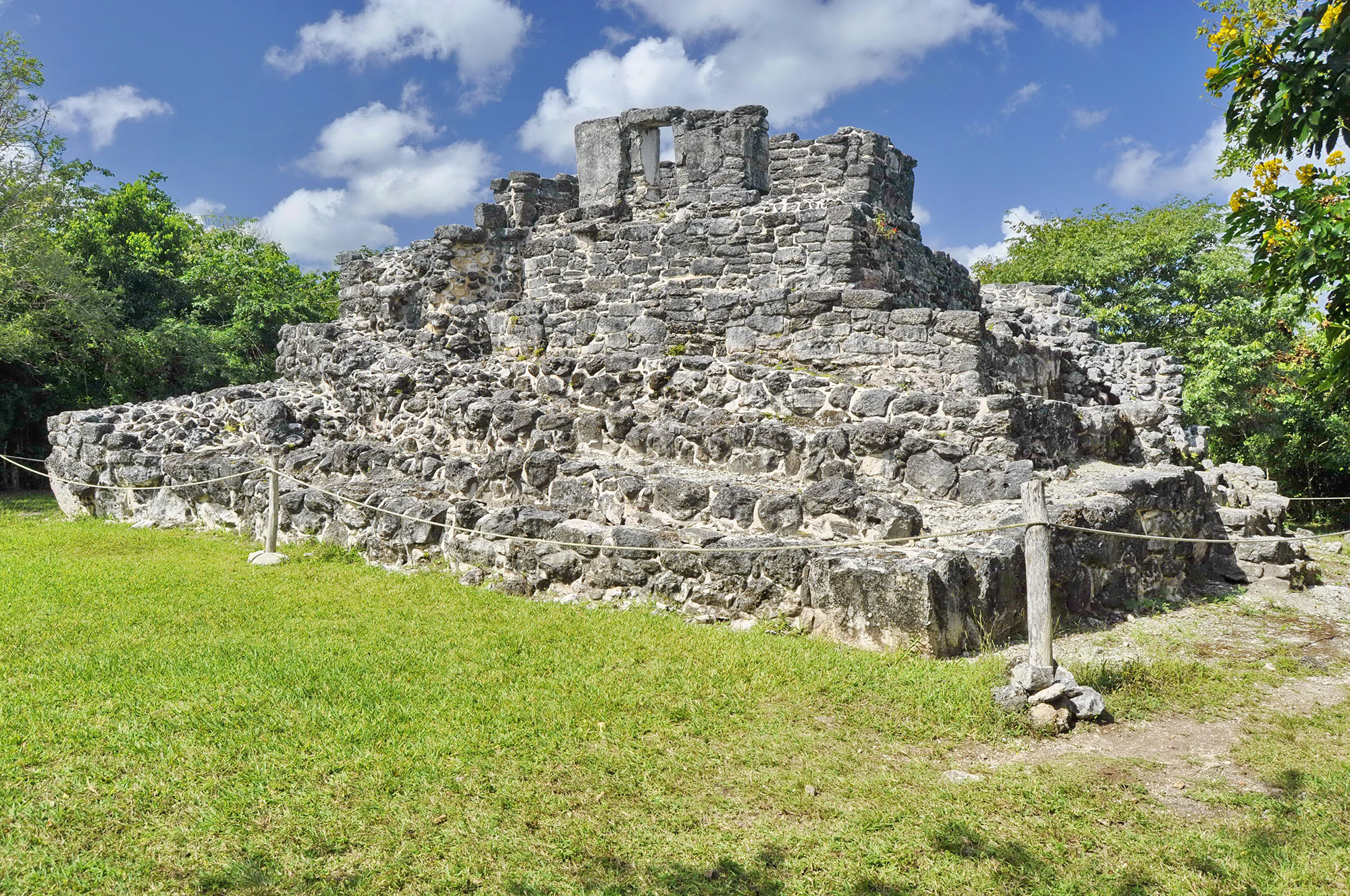 Ruins of an old building surrounded by a lawn and trees -