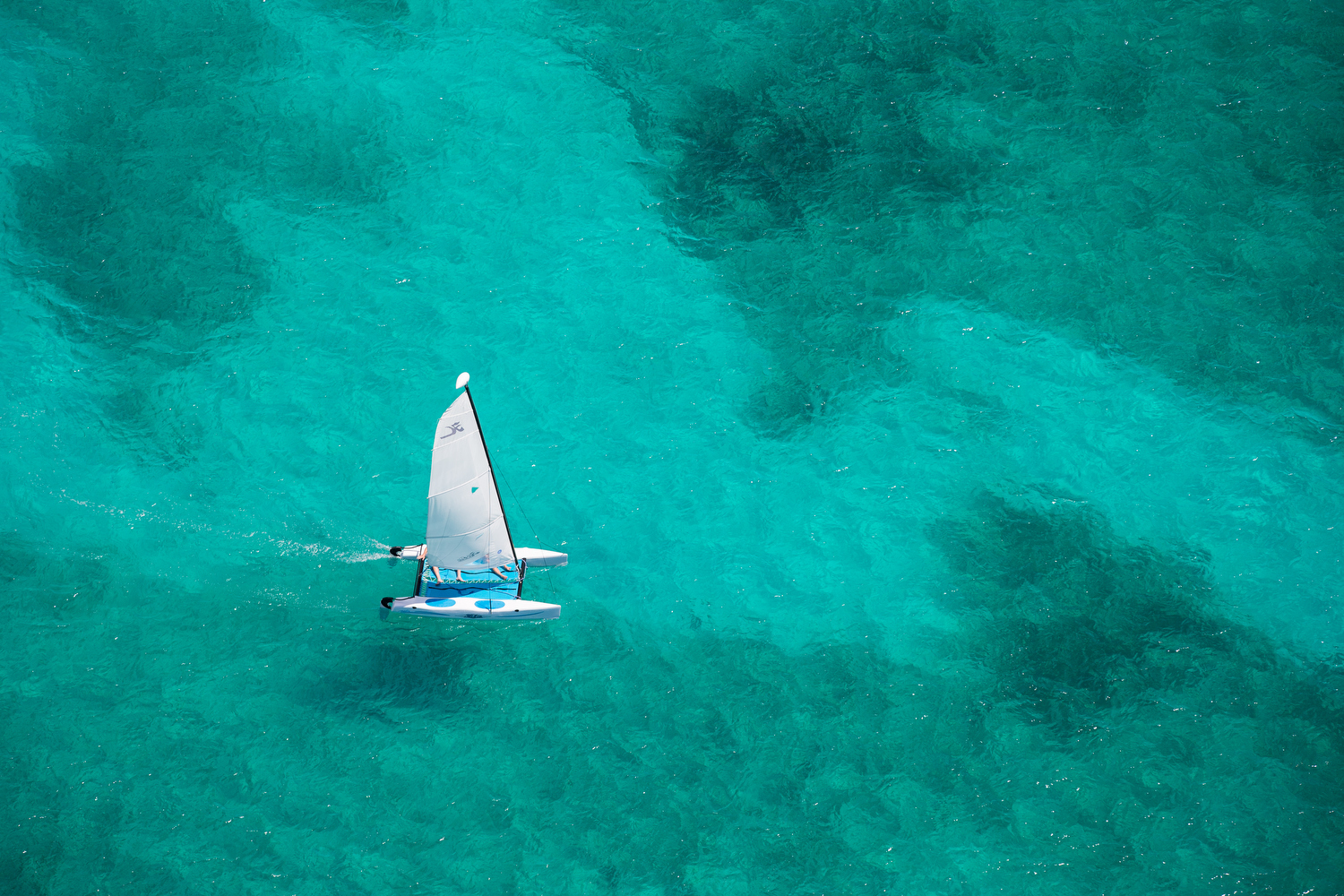 Small sailing boat on beautiful clear turquoise sea