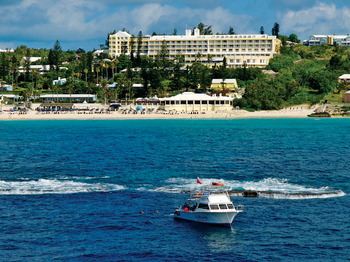 Boat sailing away from the shore, urban hotels in the background