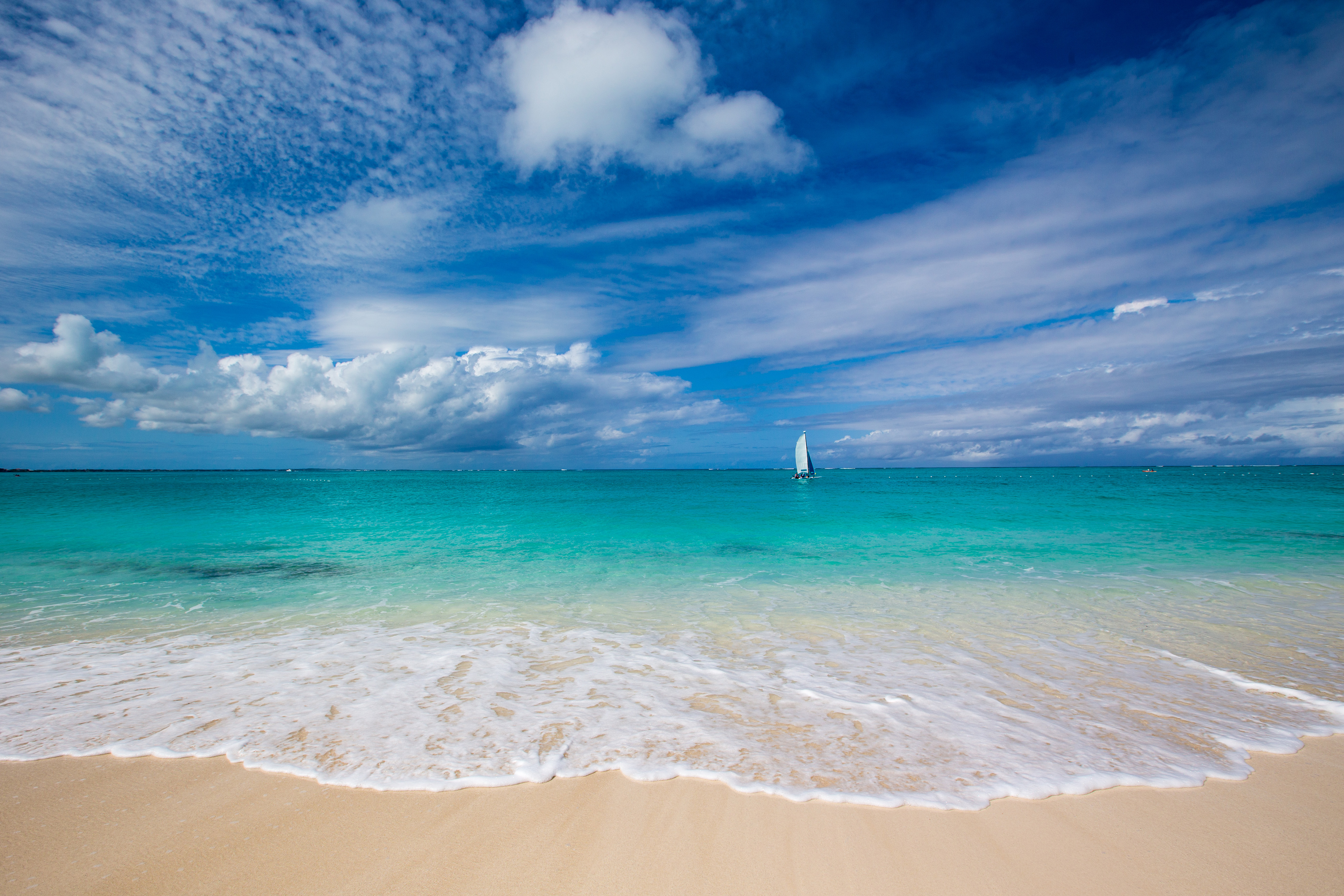 Looking out to a bright turquoise sea from a white sand beach