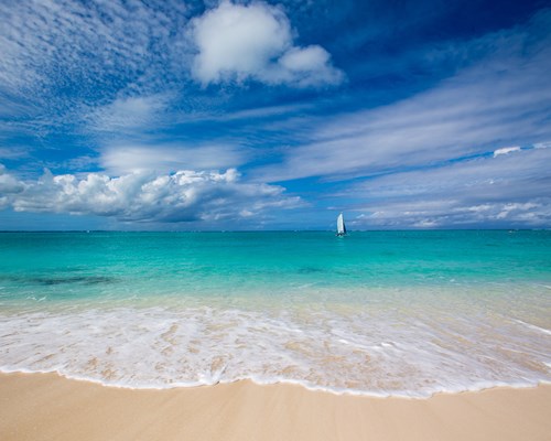 Looking out to a bright turquoise sea from a white sand beach