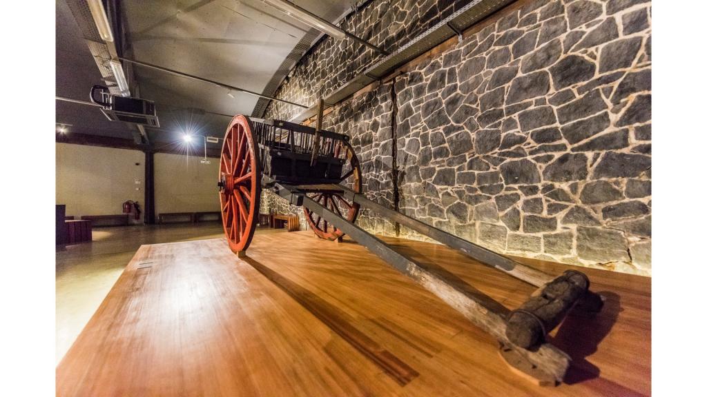 Museum display of an old carriage on wooden floor