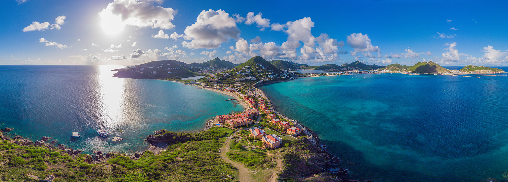 High aerial view of a mountainous tropical island surrounded by clear blue sea