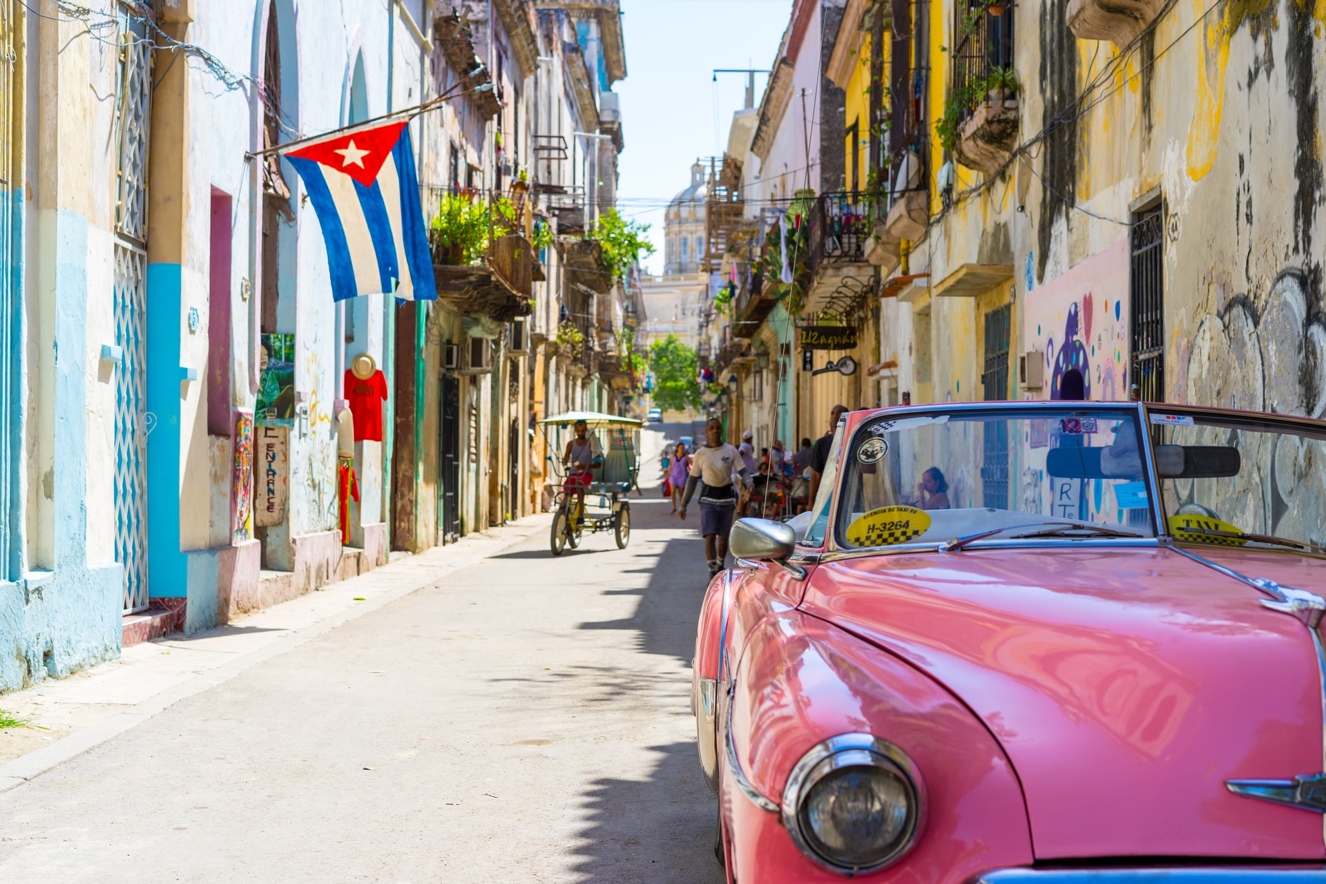 Pink convertible car parked on a quiet residential street in Havana 