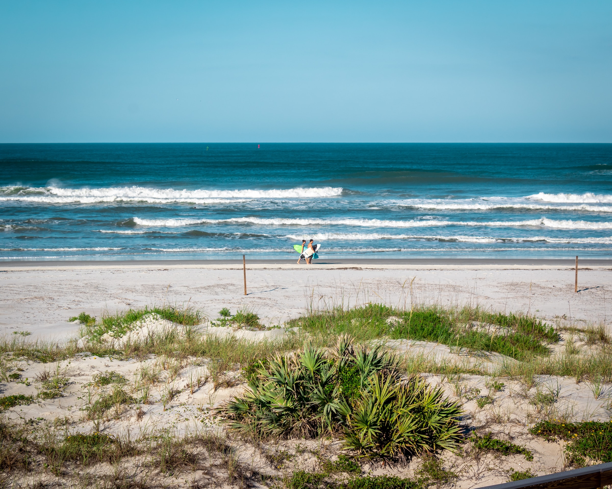 Two people walking on a natural beach