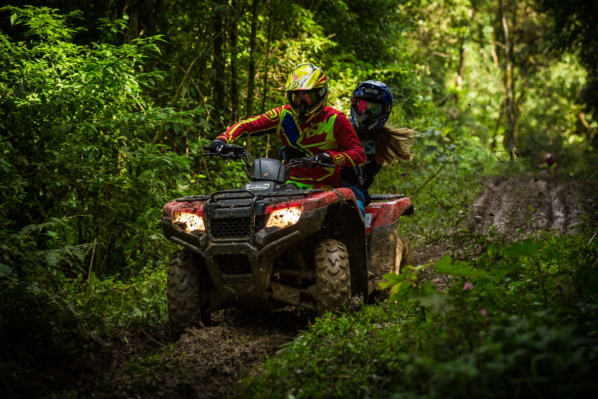 A couple quad biking in a forest